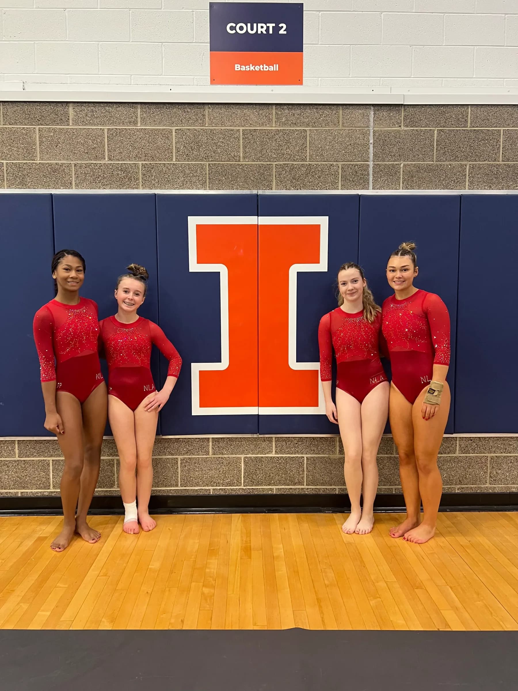 Four Next Level gymnasts together after a competition